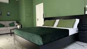 A modern bedroom with a bed, a sofa, and a nightstand. - Terrazza Moio (Naples)