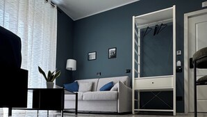 A modern living room with a marble floor, a sofa, a coffee table, and a side table with a plant. - Terrazza Moio (Naples)