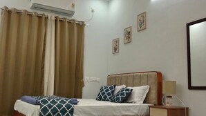 Un dormitorio con cama de madera, mesita de noche, aire acondicionado montado en la pared y lámpara en el techo.