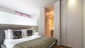 A bedroom with a bed, bedside table, lamp, and a wardrobe. - Modern Times - Covent Garden By Frankie Says (London)