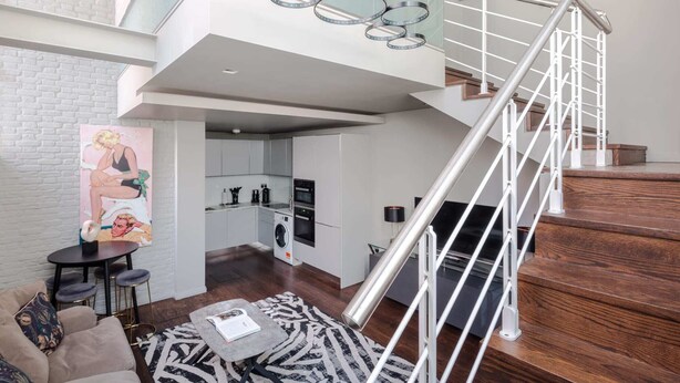 A modern apartment with a staircase, a kitchen, and a living area. - Modern Times - Covent Garden By Frankie Says (London)