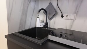 A kitchen with a black countertop, a built-in stove, and a modern faucet.