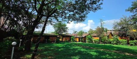 A courtyard with multiple buildings, a large tree, and well-maintained grass.