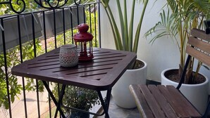 A balcony with a wooden table, a red lantern, and potted plants. - Charming bed & breakfast in delightful Hà Nội with AC, WiFi (Hà Nội)