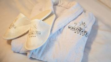 Un par de pantuflas y una toalla con el texto "Waldkater Hotel & Restaurant".