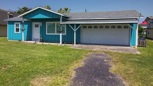 Een gelijkvloers huis met garage, voortuin en gazon.