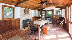 A rustic dining area with a wooden table, chairs, and a ceiling fan. - Charming 3BR Cottage + Garden, Walk to Downtown & Metra, Sleeps 6 (Geneva)