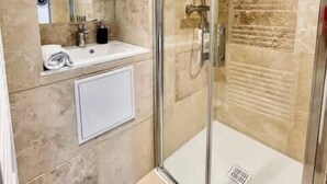 A modern bathroom with a glass-enclosed shower, a white sink, and a mirror above it. - Ben Nevis charming studio in the heart of the lively life of the Pré Carré (Annecy)