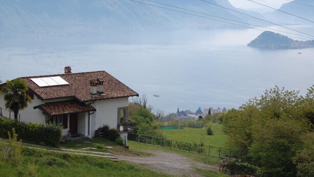 A house with a tiled roof, a small porch, and a solar panel. - TOBIA HOUSE Beautiful Lake View (San Rocco)