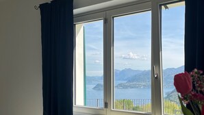 A room with a large window, a radiator, and a bed. - TOBIA HOUSE Beautiful Lake View (San Rocco)