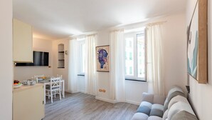 A compact living space with a kitchenette, dining area, and a sofa. - Charming Apartment Santa Margherita Ligur (Santa Margherita Ligure)