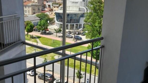 A balcony with a view of a cityscape, including a distinctive modern building with a curved facade. - Jolly house 1 (Cosenza)