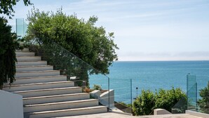 Una escalera conduce a un balcón con vistas a un cuerpo de agua.