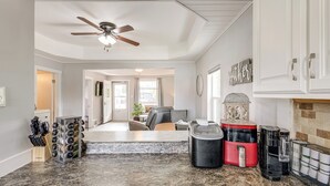 A spacious kitchen with granite countertops, a ceiling fan, and a dining area with a fireplace. - Quaint Home 16 Mi to Bear Lake: Fish, Hike & Golf! (Montpelier)
