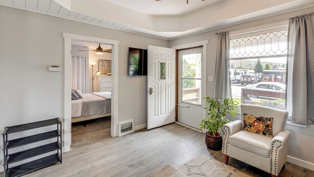 A room with a bed, a chair with a floral pillow, a ceiling fan, and a window with curtains. - Quaint Home 16 Mi to Bear Lake: Fish, Hike & Golf! (Montpelier)