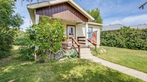 A two-story house with a front porch, a bicycle parked outside, and a flag on the porch. - Quaint Home 16 Mi to Bear Lake: Fish, Hike & Golf! (Montpelier)