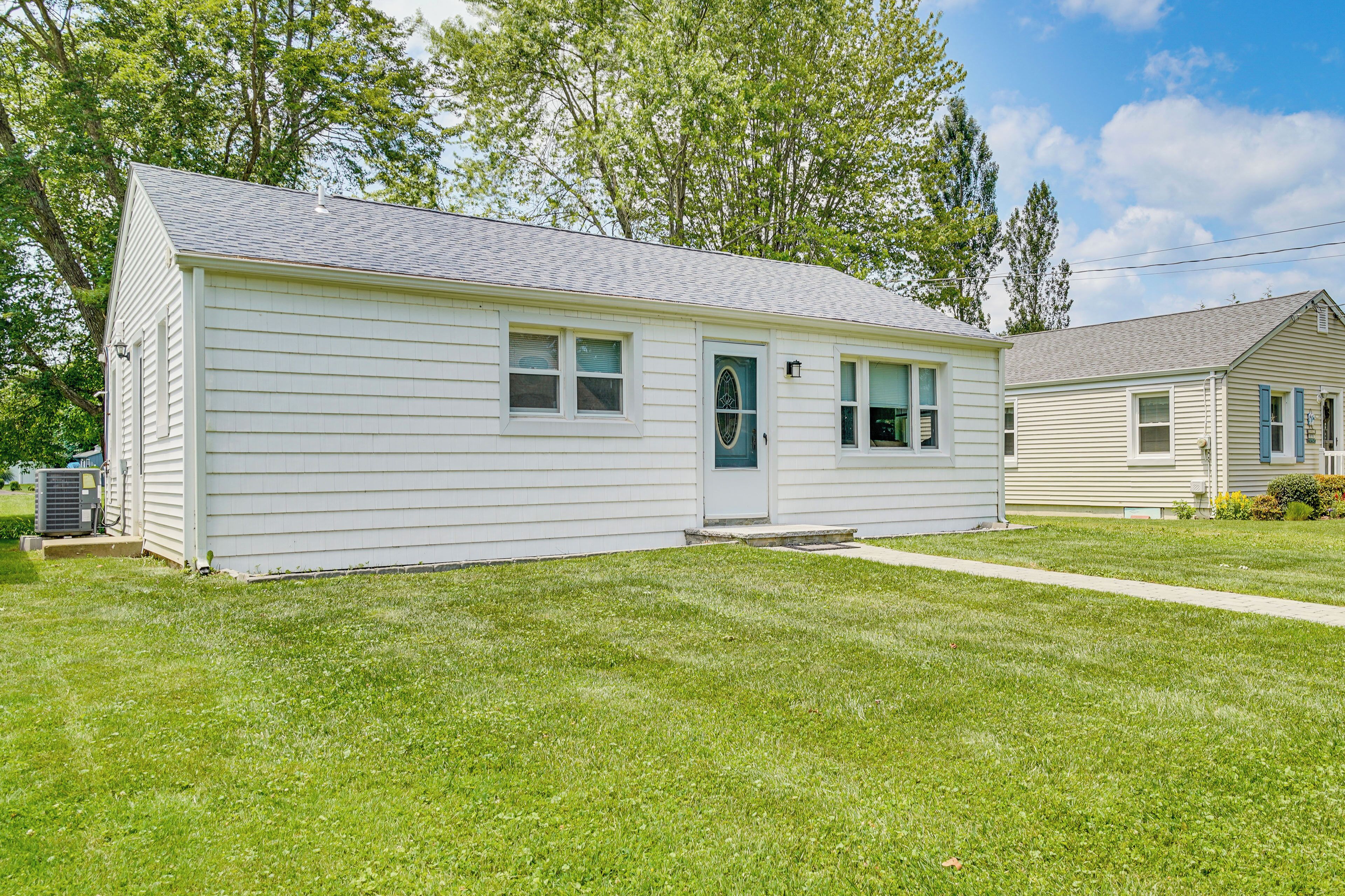 A single-story house with a front porch, a small front yard, and a side yard.