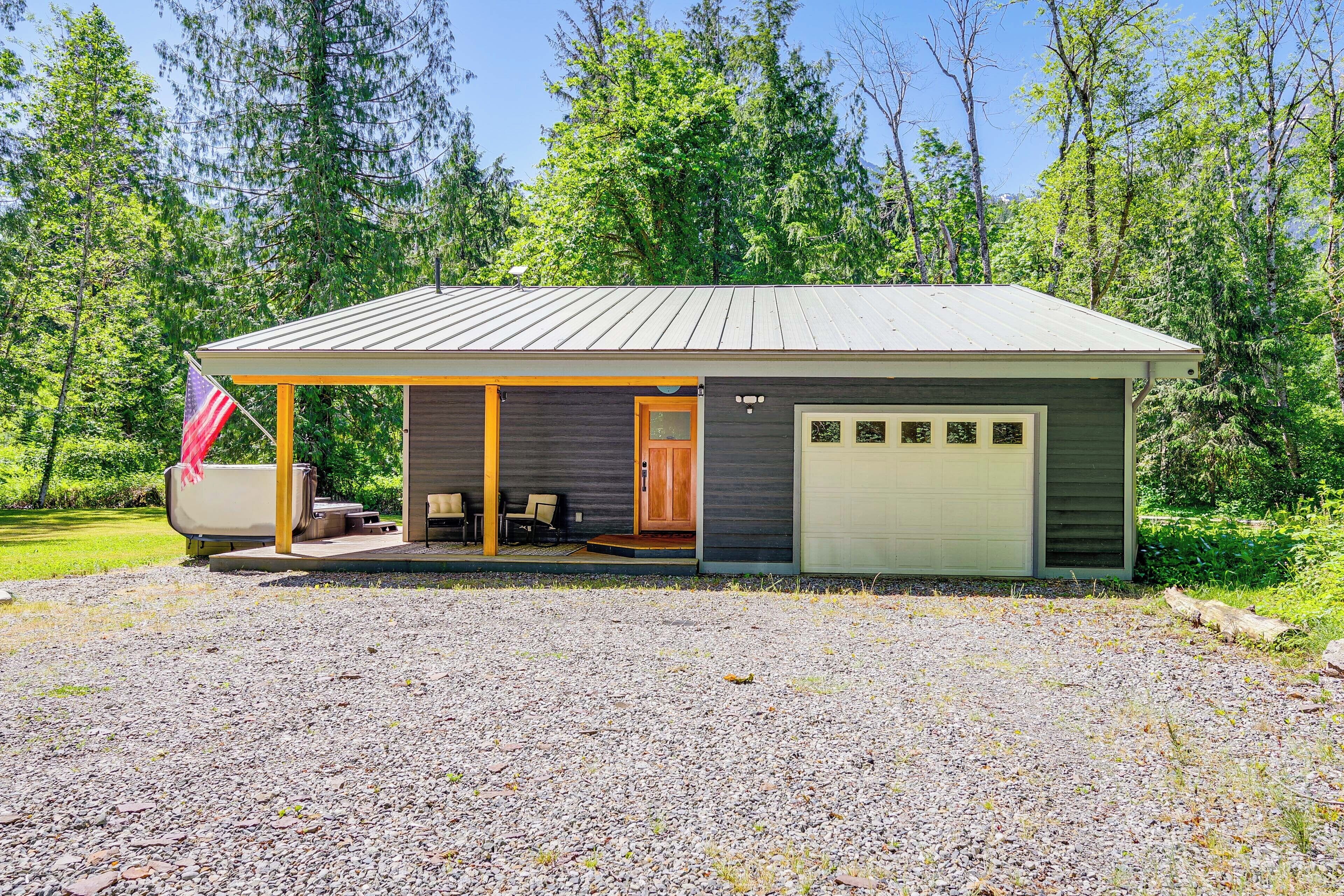 A single-story house with a covered porch, a garage, and a patio area with outdoor seating.