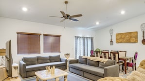 A living room with a grey sofa, a coffee table, and a ceiling fan. - 9 Mi to Dtwn Bakersfield: Pet-friendly Home (Bakersfield)