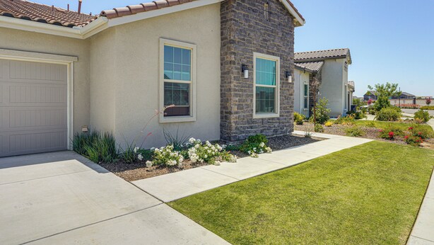 A residential house with a stone facade, a tiled roof, and a well-maintained lawn. - 9 Mi to Dtwn Bakersfield: Pet-friendly Home (Bakersfield)