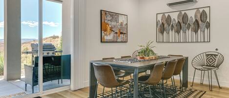 A dining area with a table, chairs, and a view through glass doors to an outdoor patio.