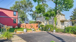 Une rue résidentielle bordée de maisons, avec un bâtiment rouge et une allée pavée.