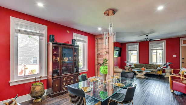 Un coin repas comprenant une table en verre, des chaises et un buffet.