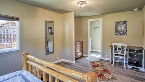 A bedroom with a wooden bed, a desk, a chair, a dresser, a mirror, and a window. - Kingston Sleeper: Unique Stay Near Silver Mountain (Kingston)