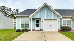 A two-story house with a front garage, a covered entryway, and a small front yard with a lawn and two bushes. - 7 Mi to Dtwn Augusta: Townhome Near Shops & Eats! (Grovetown)