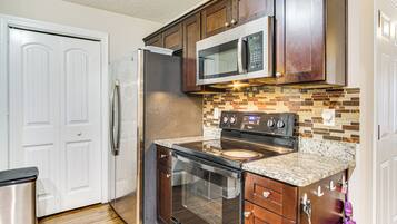A kitchen with a refrigerator, microwave, oven, and dishwasher.