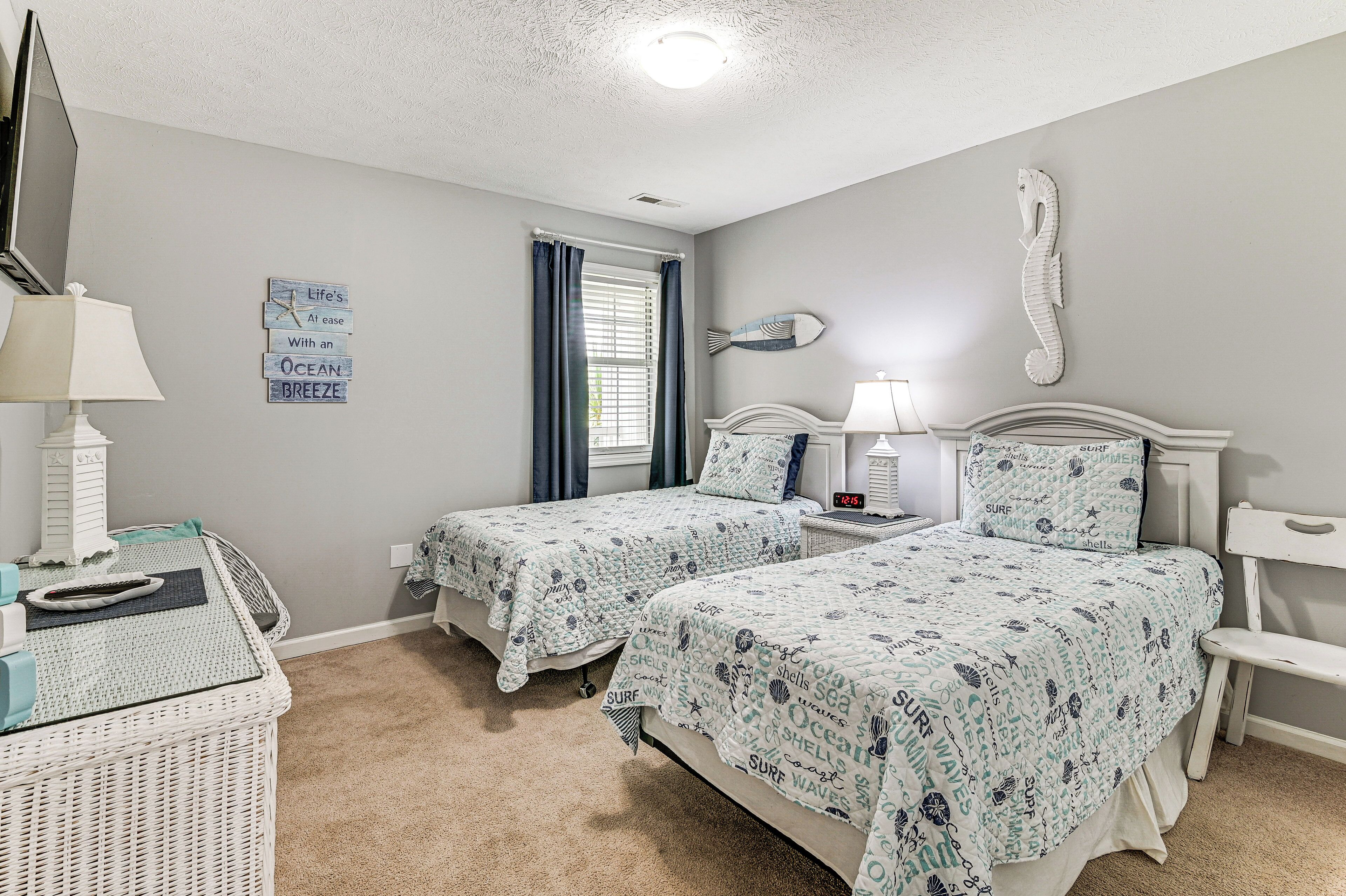 Ein Schlafzimmer mit zwei Betten, einem Fernseher und einem Schminktisch.