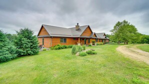 A large wooden house with a grey roof, surrounded by a well-maintained lawn and trees. - Hot Tub & Trail Access: Spacious Stockholm Retreat (Stockholm)