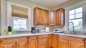 A kitchen with wooden cabinets, a countertop, a sink, and a window with blinds. - Hixton Getaway: Near Lakes & Trails! (Hixton)