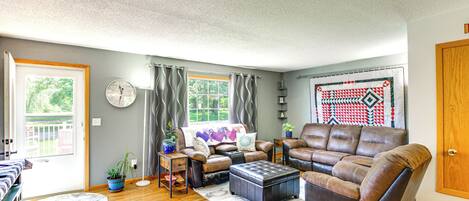 A living room with a brown leather sofa, a coffee table, and a patterned rug.