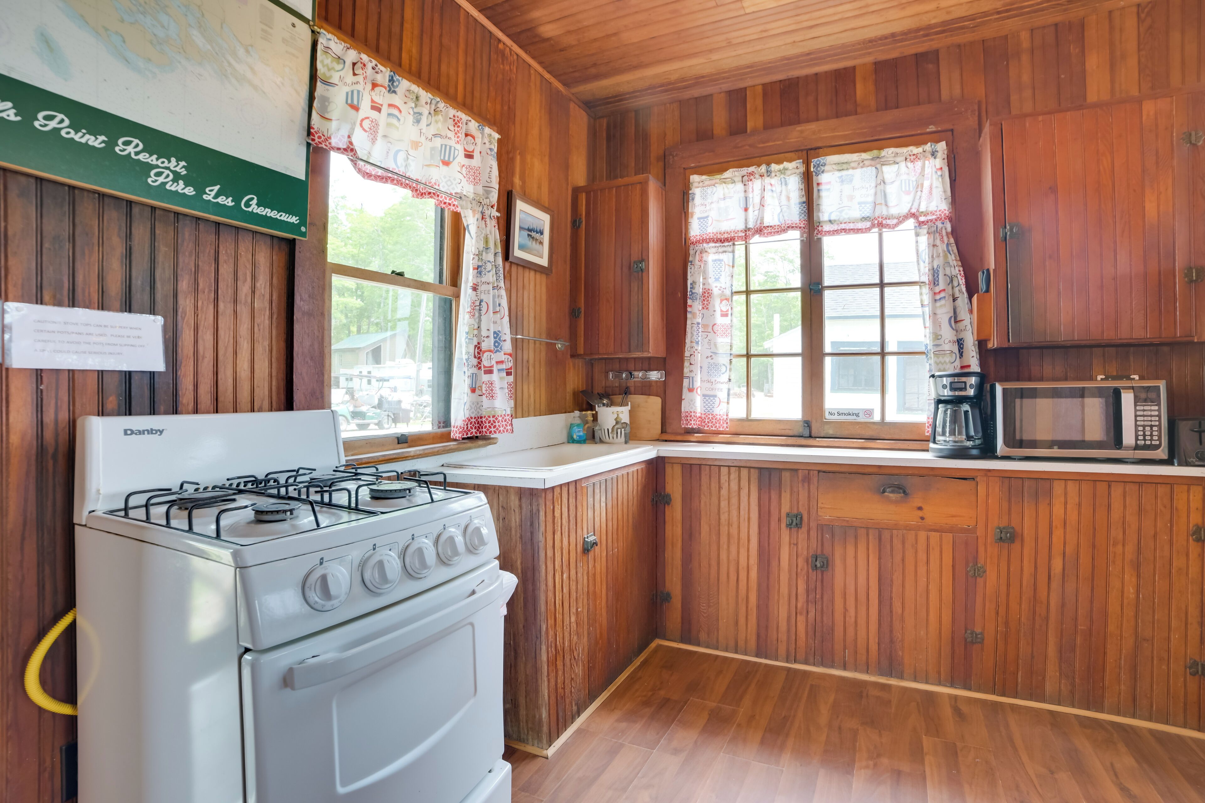 A kitchen with wooden cabinets, a stove, and a microwave.
