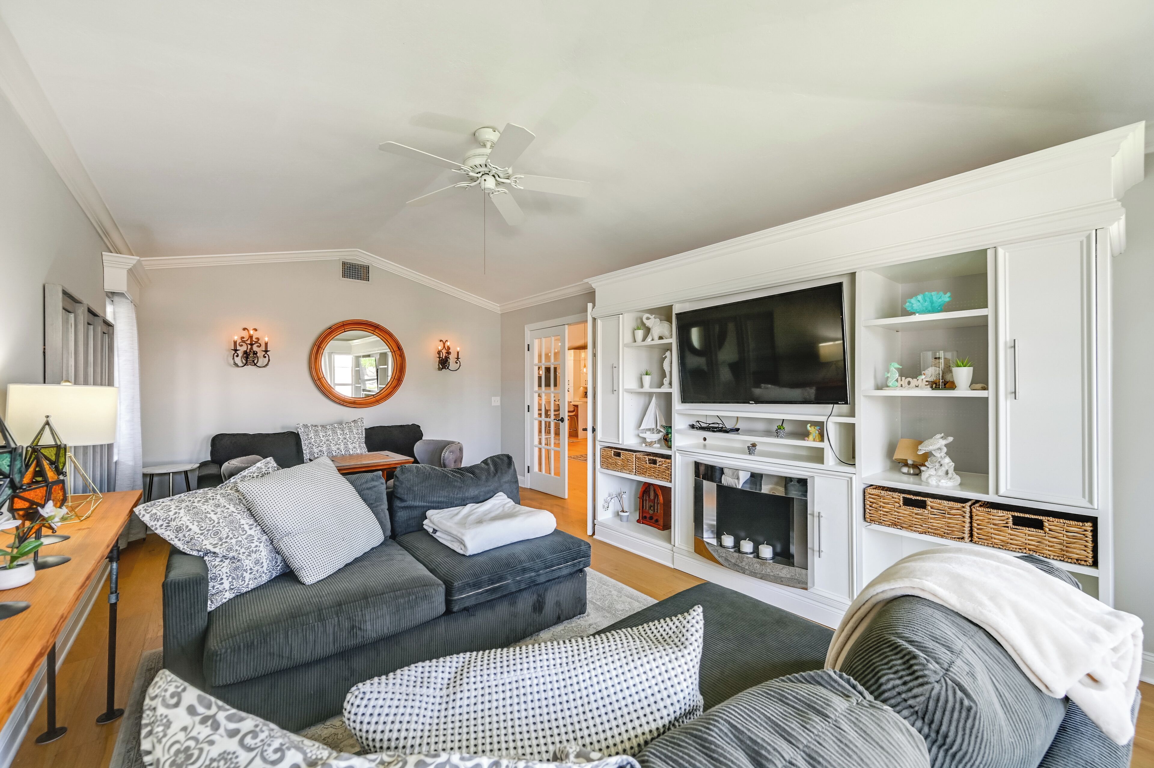 A modern living room with a grey sofa set, a wooden coffee table, and a white fireplace.