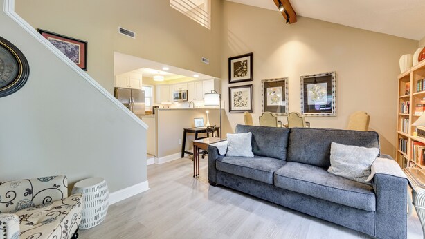 A modern living room with a grey sofa, a patterned armchair, and a bookshelf. - Gastonia Family Home < 20 Mi to Crowders Mtn (Gastonia)