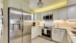 A modern kitchen with white cabinets, stainless steel appliances, and a light wood floor. - Gastonia Family Home < 20 Mi to Crowders Mtn (Gastonia)