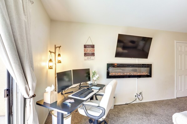 A home office with a desk, computer, and TV. - North Las Vegas Home w/ Hot Tub - 14 Mi to Strip! (North Las Vegas)