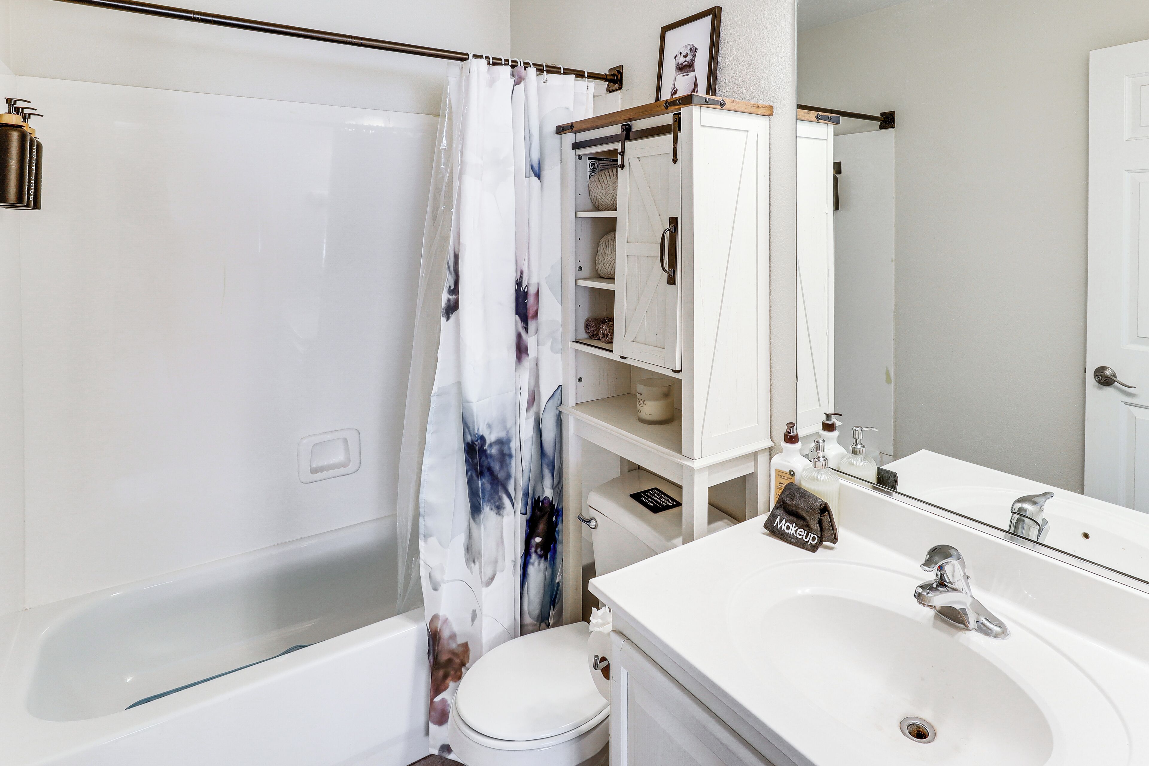 A bathroom with a bathtub, toilet, and a sink with a mirror.