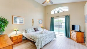 A bedroom with a bed, bedside tables, a TV, and a window with curtains. - Family Home w/ Pool: Visit Disney & Orlando Parks! (Davenport)