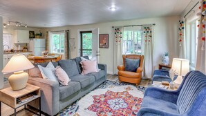 A living room with a grey sofa, a blue armchair, and a patterned rug. - Hike On-site: Mountain-view Hideaway in Durango (Durango)