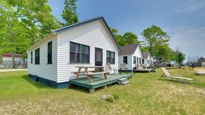 A white house with a porch and a picnic table. - Free Boat Rentals! Beachside Les Cheneaux Cabin (Cedarville)