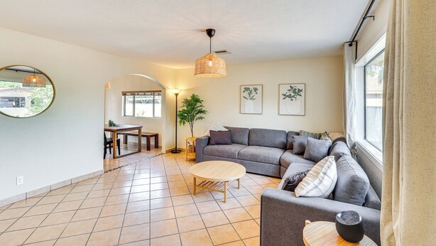 A living room with a gray sofa, a round coffee table, and a hanging light fixture. - Walk to Colorado River: Family Home w/ Yard! (Bullhead City)
