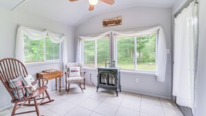 A cozy room with a rocking chair, a small table, and a vintage stove.