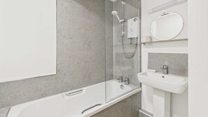 A modern bathroom with a glass-enclosed shower, a white bathtub, and a pedestal sink. - Host Stay Look Flat (Scarborough)