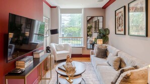 A modern living room with a television, a sofa, a coffee table, and a bookshelf. - The Honourable - Bloomsbury Square By Frankie Says (London)