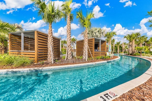 Una piscina con estructuras de madera y palmeras.