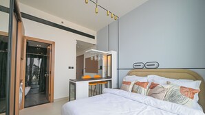 Ett modernt hotellrum med en säng, ett skrivbord och ett badrum.