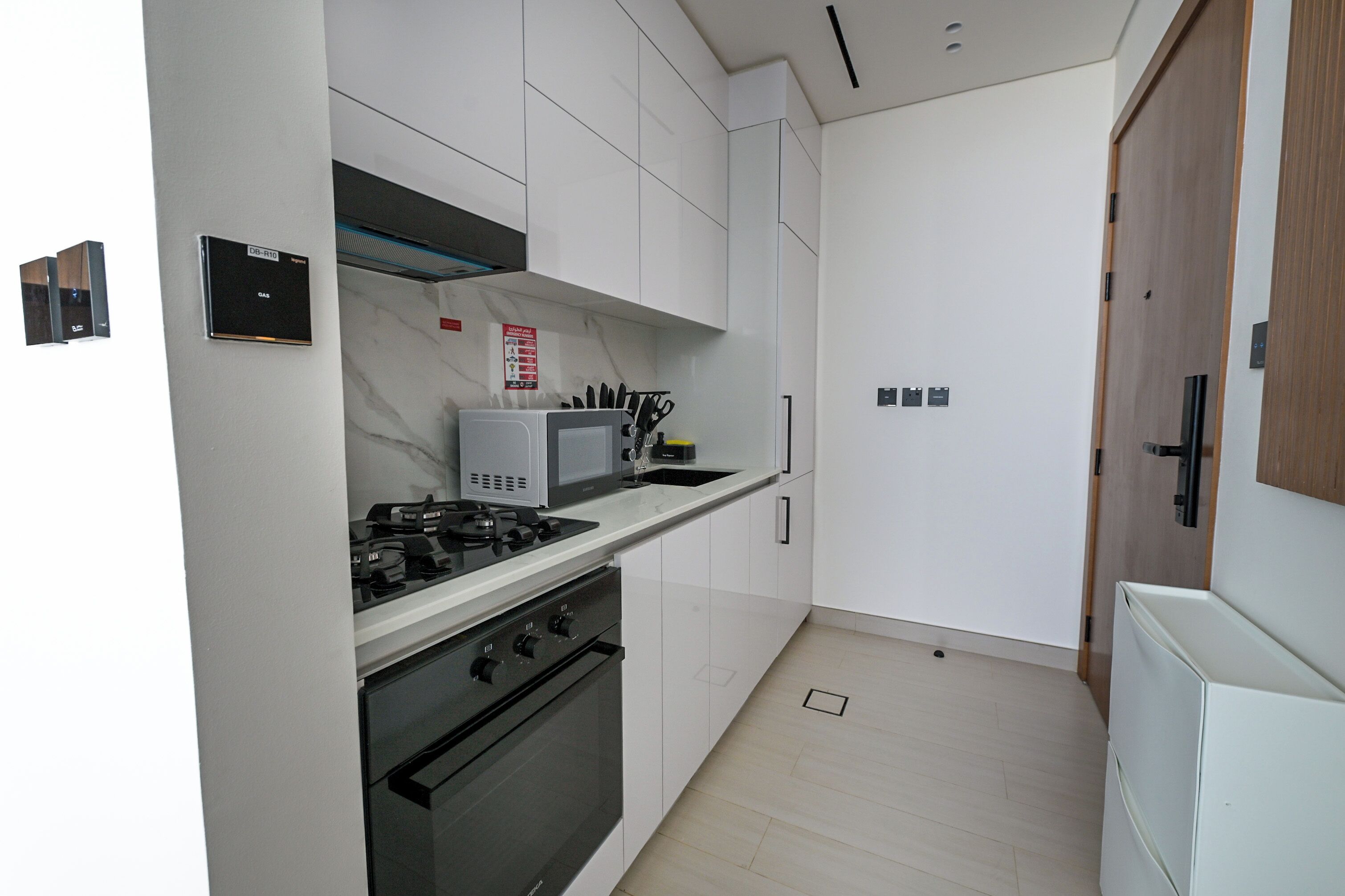 Una cocina moderna con gabinetes blancos, estufa a gas, horno y microondas.